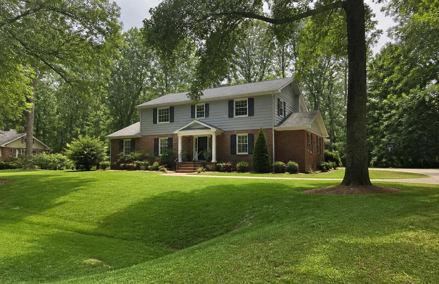 Greensboro, North Carolina neighborhood home with mature trees and a brick foundation