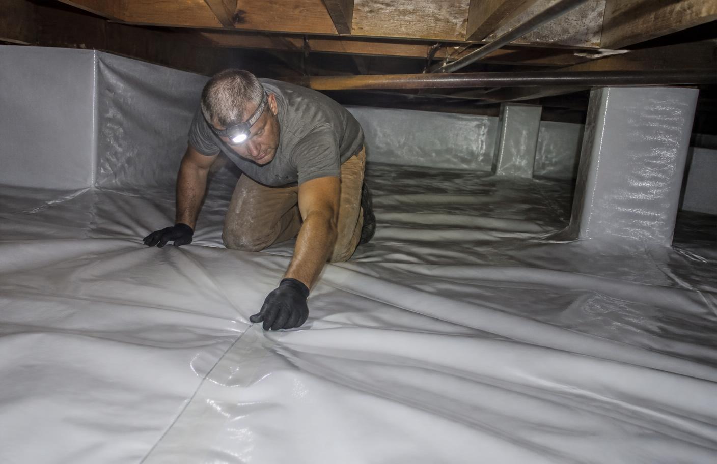 Vapor barrier installed across the ground inside a crawl space